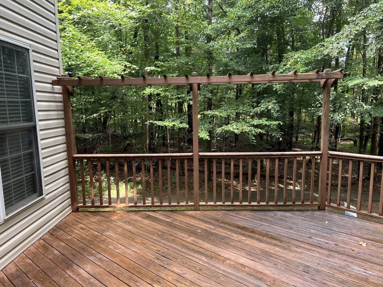 A weathered pergola deck with gray, worn boards — typical condition before a restoration quote in the Baltimore area.
