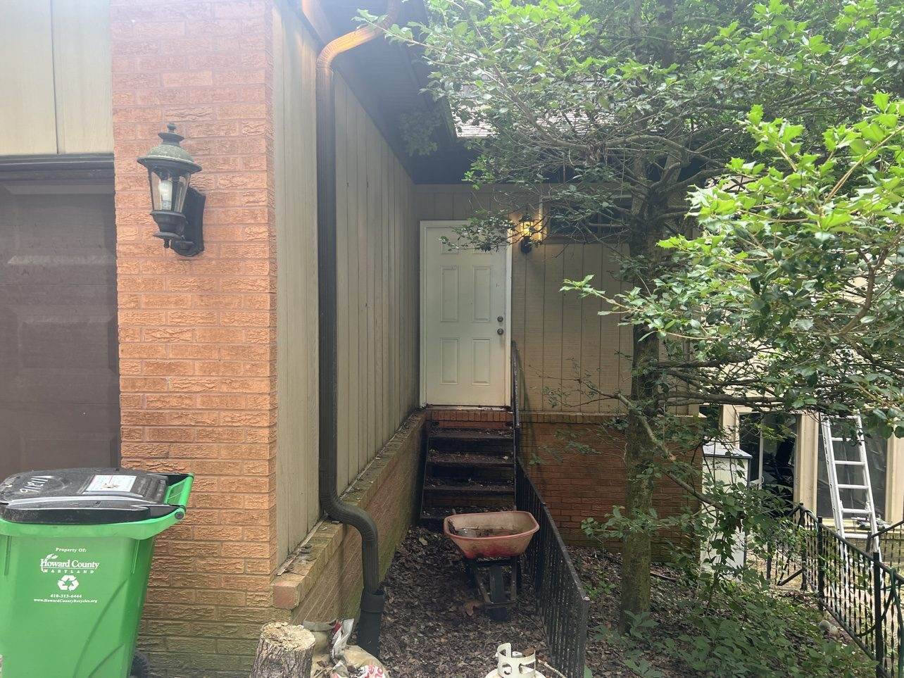 A downspout running down the side of a brick Howard County home.