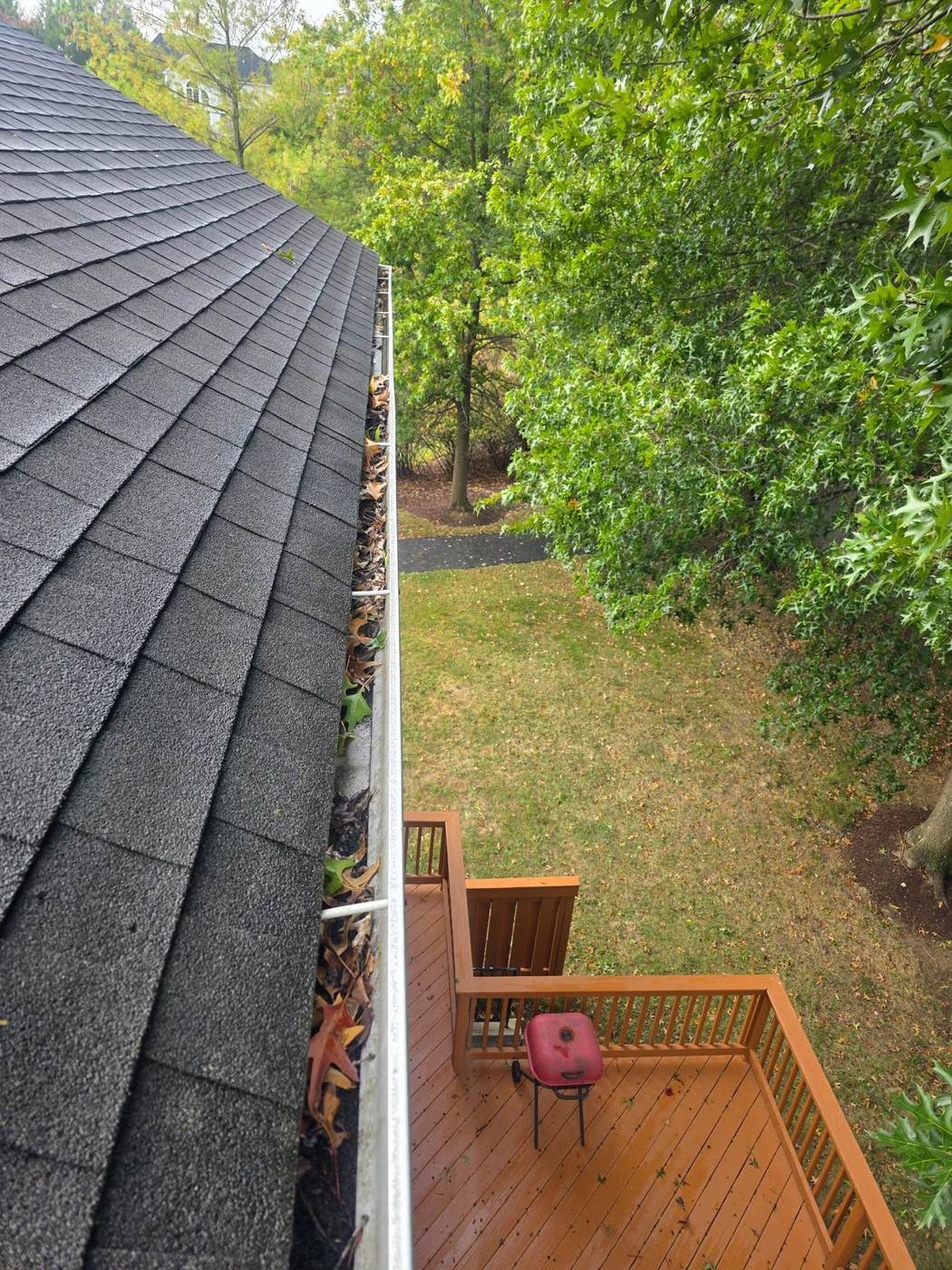 A leaf-clogged gutter before cleaning — the kind of packed debris gutter guards are designed to keep out of the trough.